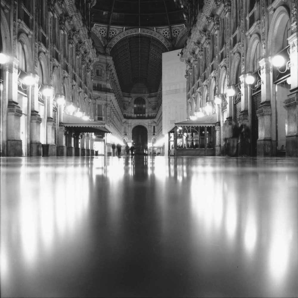 Riflesso su pavimento bagnato nella Galleria Vittorio Emanuele di notte vista dal basso verso Piazza Leonardo da Vinci