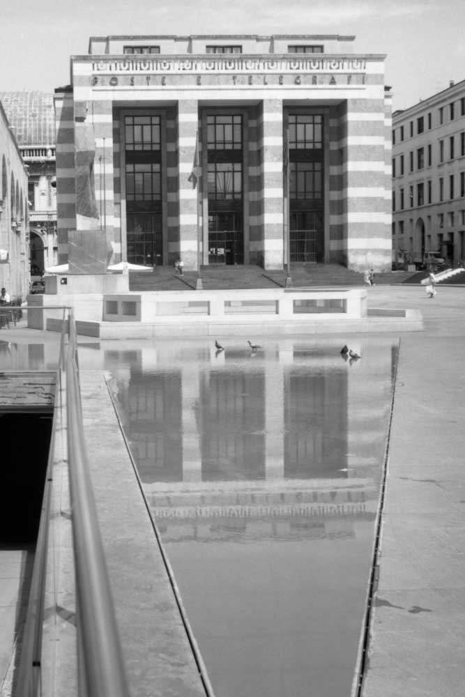 Palazzo delle poste riflesso nella fontana in piazza della Vittoria a Brescia